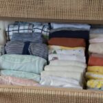 Pliage des vêtements de bébé à la verticale dans ce tiroir en rotin.
