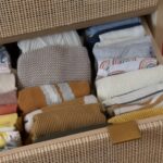 Pliage des vêtements de bébé à la verticale dans ce tiroir en rotin.