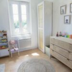 Chambre de bébé réorganisée et accueillante. Les jouets, livres et vêtements ont trouvé leur place.