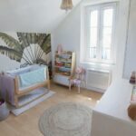 Chambre de bébé réorganisée et accueillante. Le berceau et les jouets ont trouvé leur place.