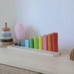 Mise en valeur de beaux jouets en bois et coloré sur le dessus de la commode. Organisation et esthétisme sont les clés d’un rangement pérenne.