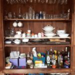 Vaisselier regroupant tous les verres, les services à thé et café, plats de présentation, linge de table, décorations de table et apéritifs.