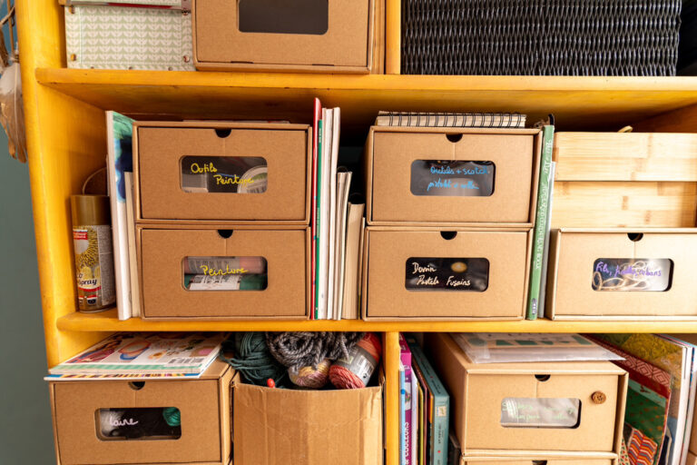 Les boîtes-titoirs utilisées sur l’étagère pour catégoriser et contenir.