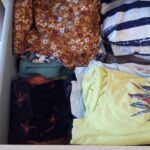 Une seconde commode avec à nouveau les vêtements empilés dans les tiroirs.