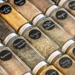 Épices rangées dans des bocaux identiques étiquetés pour une parfaite visibilité.